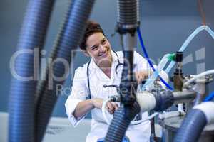 Woman vet smiling and posing behind medical machine