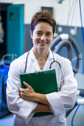 Portrait of smiling woman vet holding documents