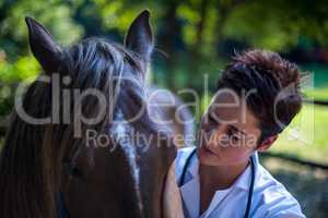 Portrait of woman vet examining a horse