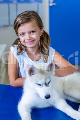 Portrait of little girl smiling and posing with a cute puppy