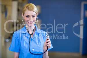Portrait of woman vet smiling and having a stethoscope on her ea