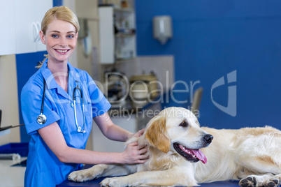 Woman vet smiling and posing with a dog