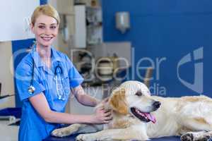 Woman vet smiling and posing with a dog