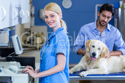 Woman vet smiling and posing in front of owner with his dog