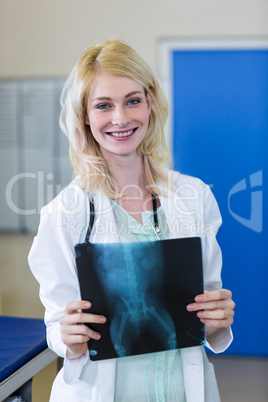 Portrait of smiling woman vet holding a dogs x-ray