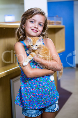 Portrait of little girl bringing a kitten