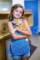 Portrait of little girl bringing a kitten