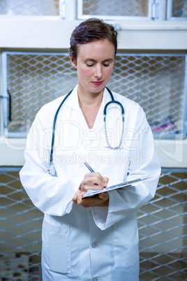 A woman vet taking notes with clipboard