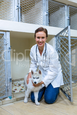 A woman vet posing and smiling with a dog