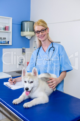 A woman vet posing and smiling with a dog