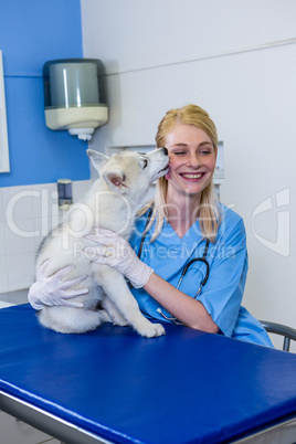 A dog kissing a woman vet