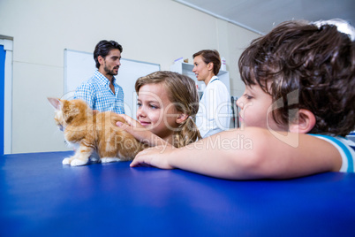 Children petting a kitten