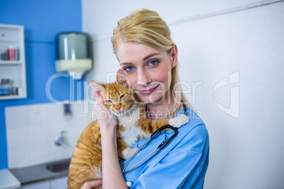 A woman vet posing and smiling with a cat