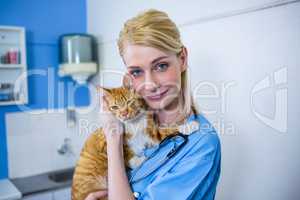 A woman vet posing and smiling with a cat