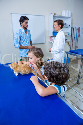 Children petting a kitten