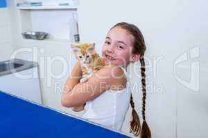 A little girl bringing a kitten
