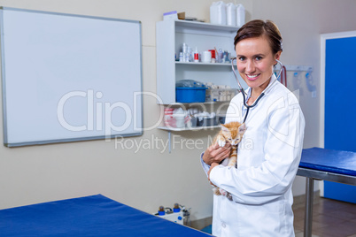 A woman vet posing and smiling with a kitten