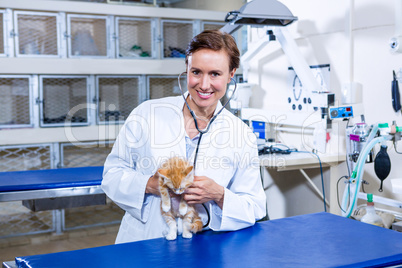 A smiling woman vet holding a cute cat