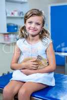 Cute girl holding her rabbit and looking at the camera