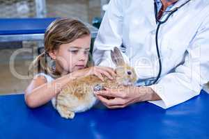 Little girl petting her sick rabbit