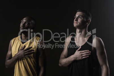 Portrait of basketball players looking up and putting hand on he