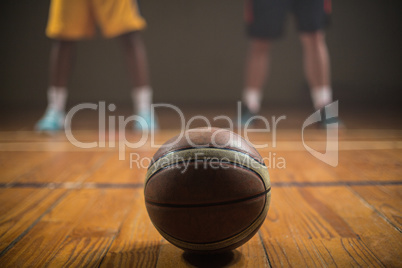Close up on basketball putting on the floor in front of basketba