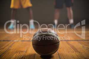 Close up on basketball putting on the floor in front of basketba