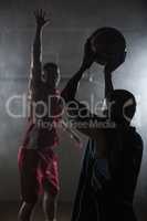 Portrait of two men playing basketball