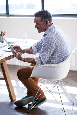 Profile view of a businessman working on digital tablet