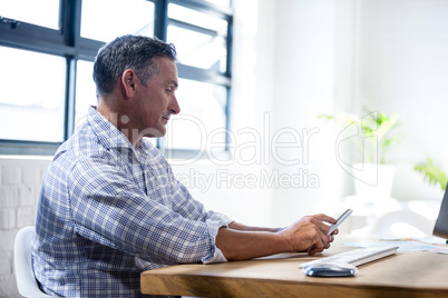 Profile view of a serious man using a smartphone