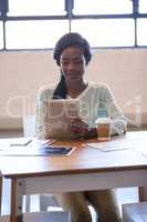 A serious woman working on digital tablet