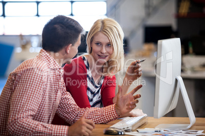 Two colleagues working at computer desk