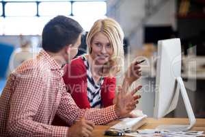 Two colleagues working at computer desk