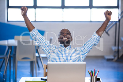 Front view of businessman celebrating success with arms up