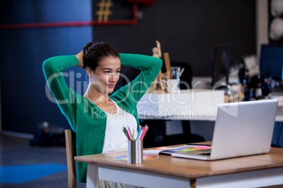 Young businesswoman resting on chair with hands behind head