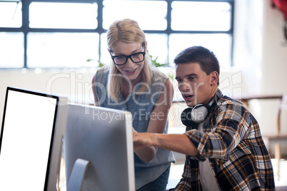 Colleague helping another with computer