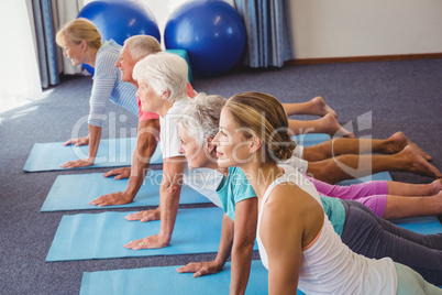 Seniors and fitness instructor stretching their legs