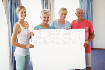 Seniors and fitness instructor holding a blank paper