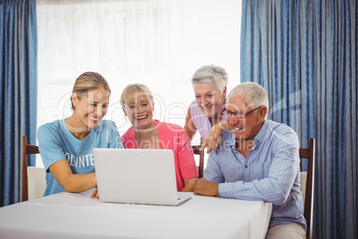 Seniors and woman using laptop