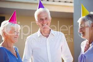 Portrait of seniors smiling with party hats on head
