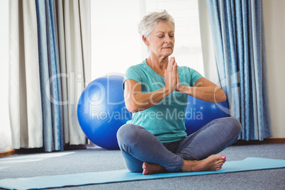 Portrait of senior woman sitting in lotus position