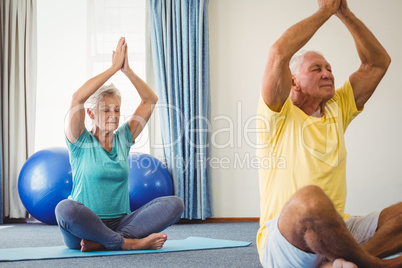 Side view of seniors doing yoga