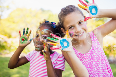 Portrait of cute girls with make up having coloured hands