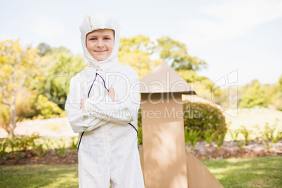 Portrait of cute boy with astronaut dress posing next to a rocke