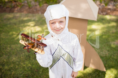 Portrait of cute boy with astronaut dress holding a little plane