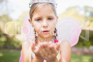 Portrait of cute girl pretending to be a fairy blowing kiss