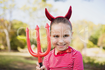 Portrait of cute girl pretending to be a devil
