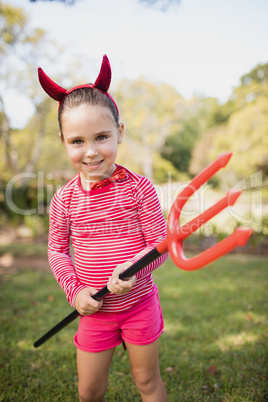 Portrait of cute girl smiling and pretending to be a devil