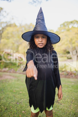 Cute girl with witch dress pointing the camera