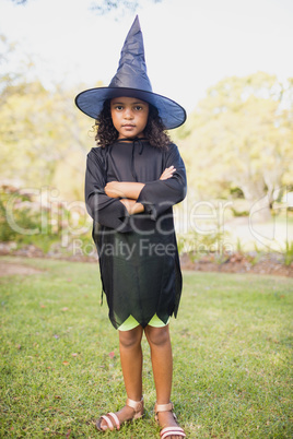 Cute girl with witch dress posing with crossed arms